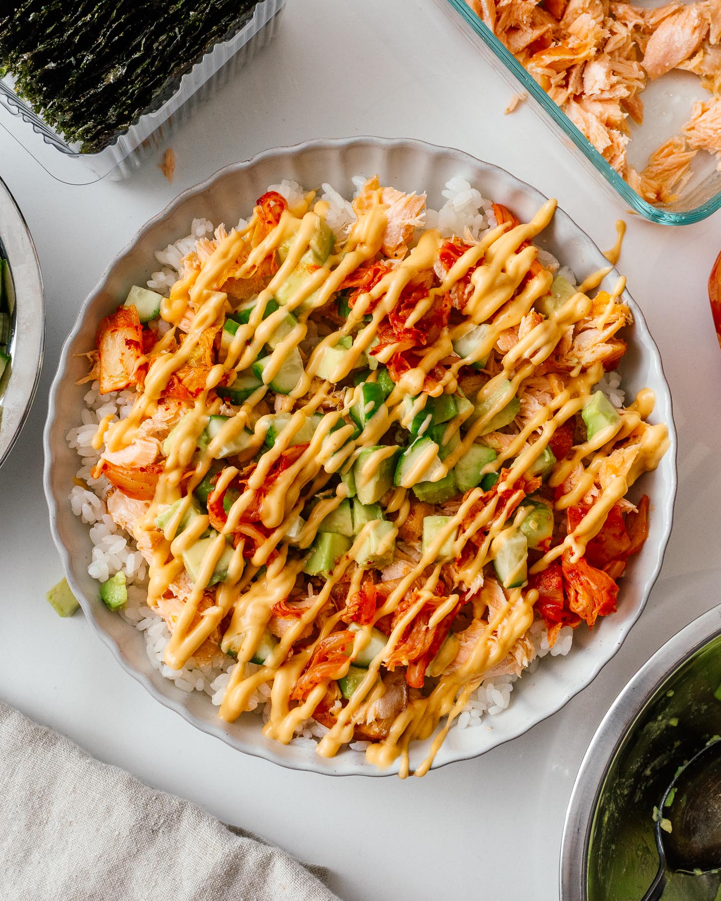 Salmon rice bowl drizzled all over with creamy Kewpie mayo and spicy sriracha